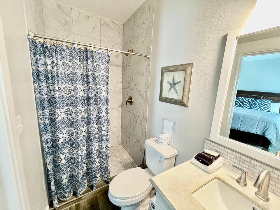 Ground-floor bath with ocean-blue touches — a refreshing space to rinse off after a day in the sun and sand.