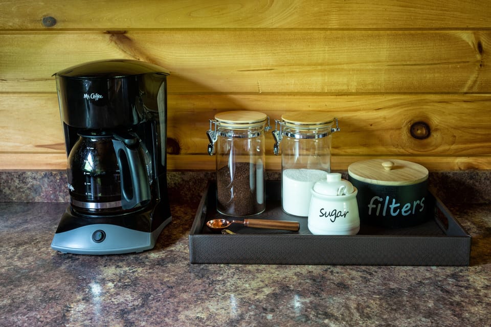 Drip coffee maker and complimentary coffee, creamer, and sugar. 