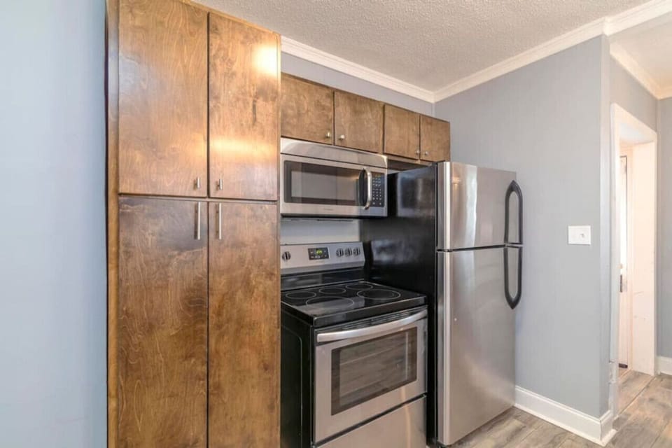 The kitchen has stainless steel appliances. There is a full size refrigerator, microwave, range, and dishwasher.
