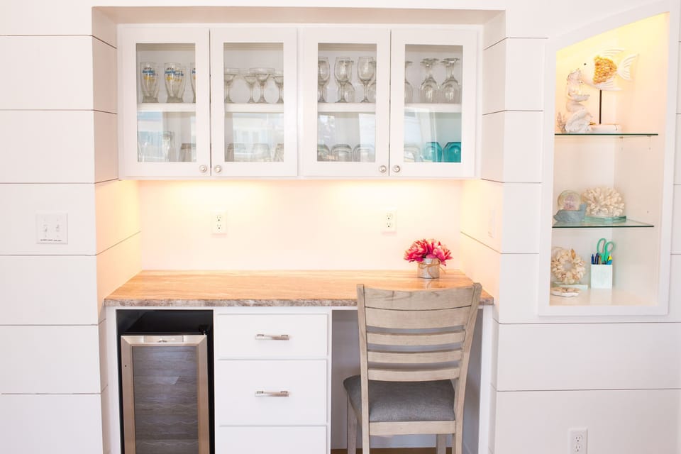 Bar area with plenty of glassware and a wine fridge.