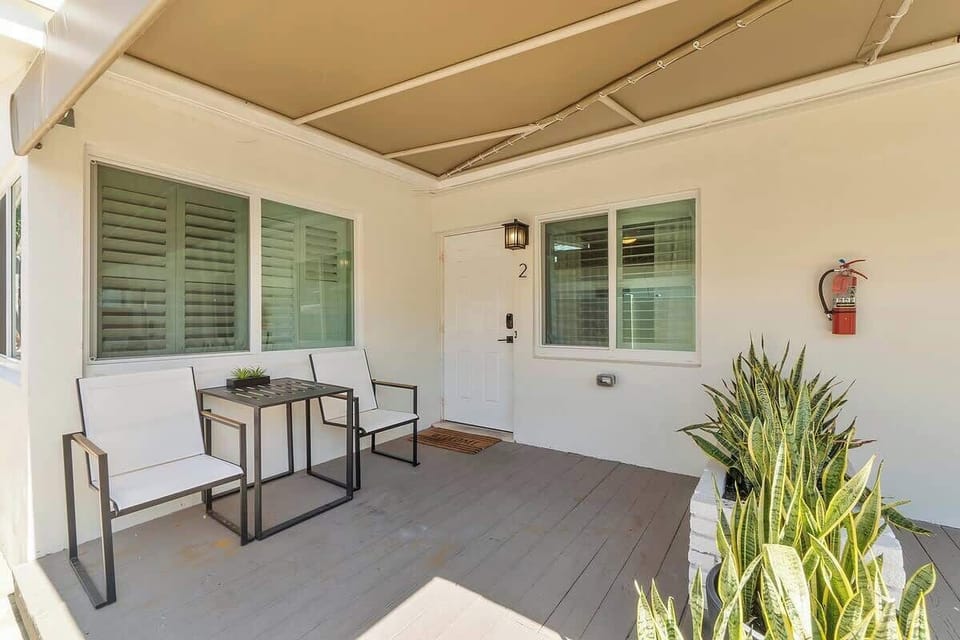 The front porch is shaded with a large awning and a private table for two.