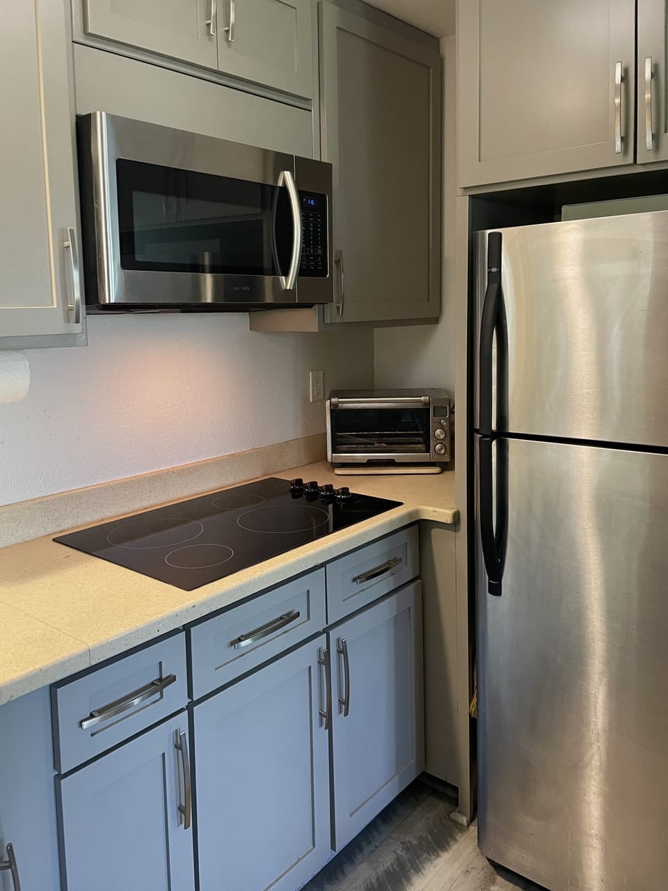 Kitchenette with cooktop, microwave, toaster oven, dishwasher and refrigerator.