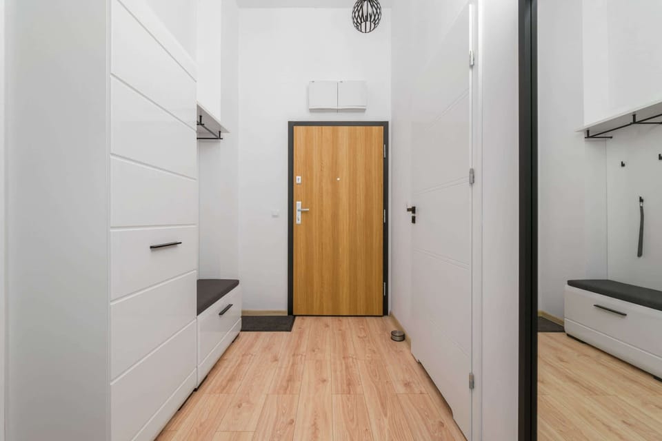 Another angle of a hallway, showcasing additional white doors and wooden accents. Bright and clean design.