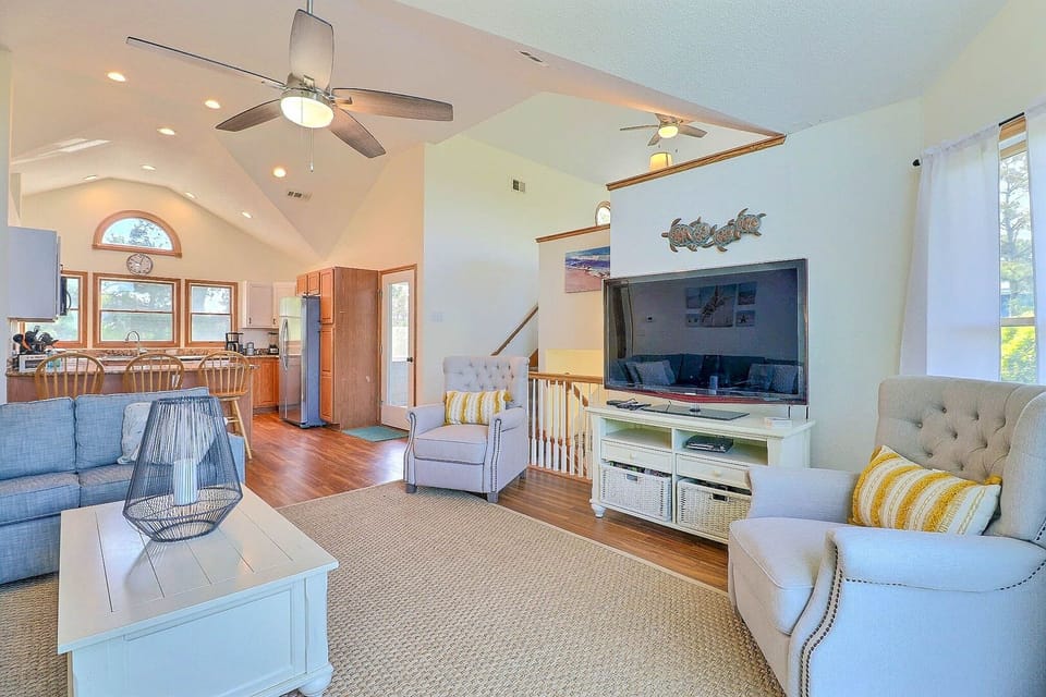 Blue Currituck Sound views abound from the bright and spacious top-level great room, with comfortable furnishings around the flat-screen TV.
