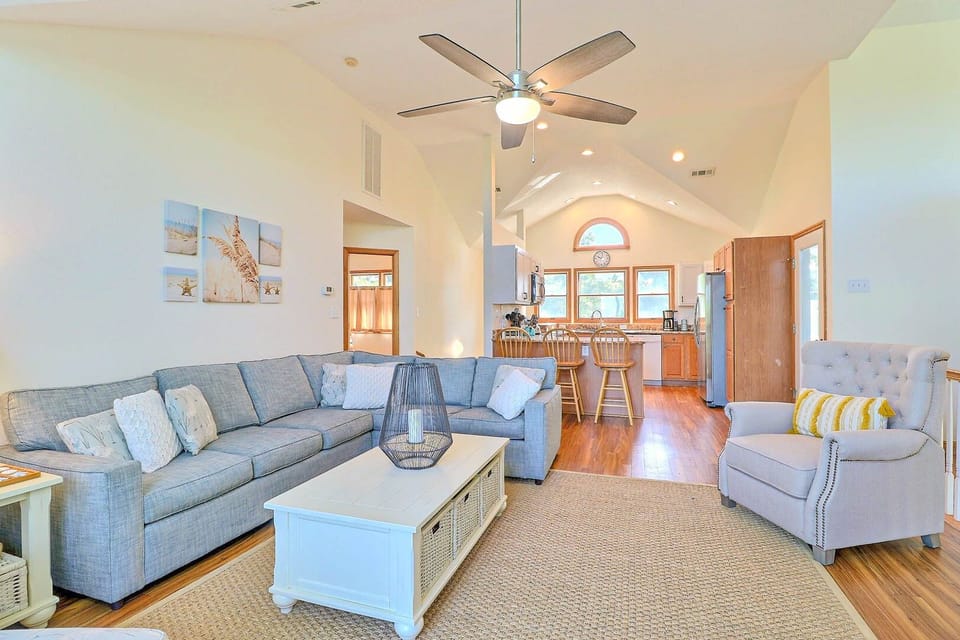 Blue Currituck Sound views abound from the bright and spacious top-level great room, with comfortable furnishings around the flat-screen TV.
