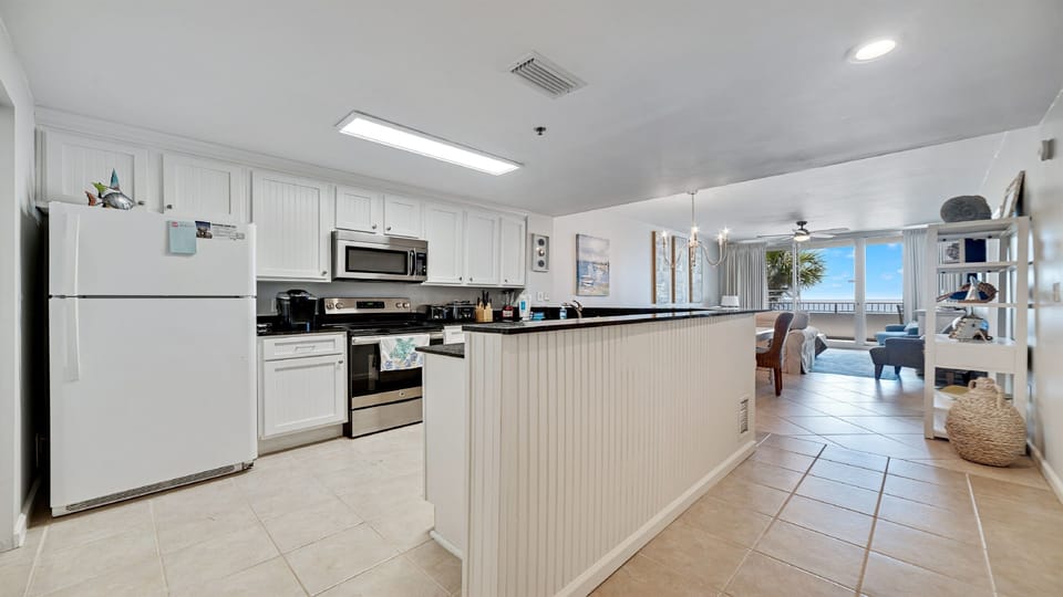 This fully functional kitchen boasts stainless steel appliances, sleek countertops, a decorative backsplash, and ample cabinet storage, ideal for everyday cooking and entertaining.
