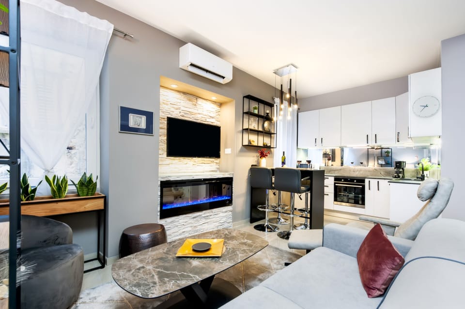 Deluxe Apartment | Living area | 58-cm flat-screen TV with cable channels, TV, smart speakers