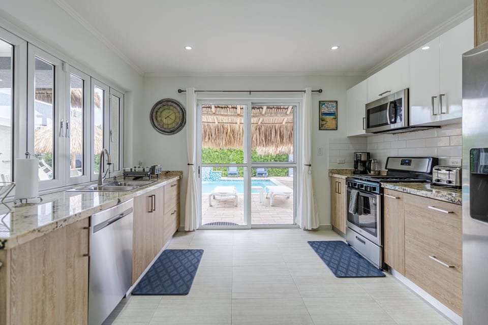Kitchen with gas stove, microwave, dishes & cooking items; refrigerator/freezer.