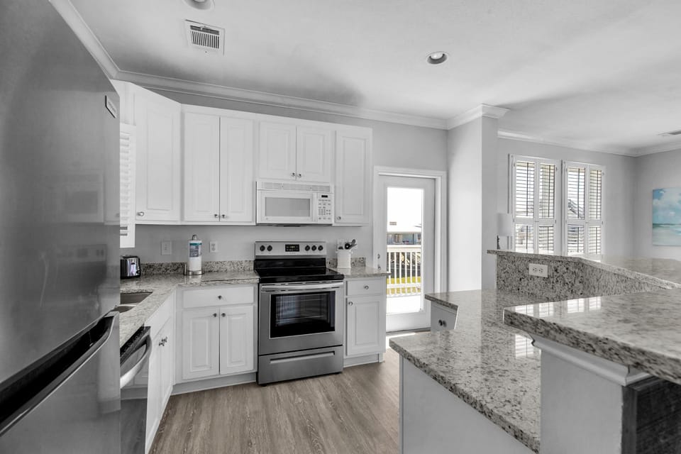 Bright, modern kitchen with gleaming granite countertops and stainless steel appliances, perfect for creating memorable vacation meals.