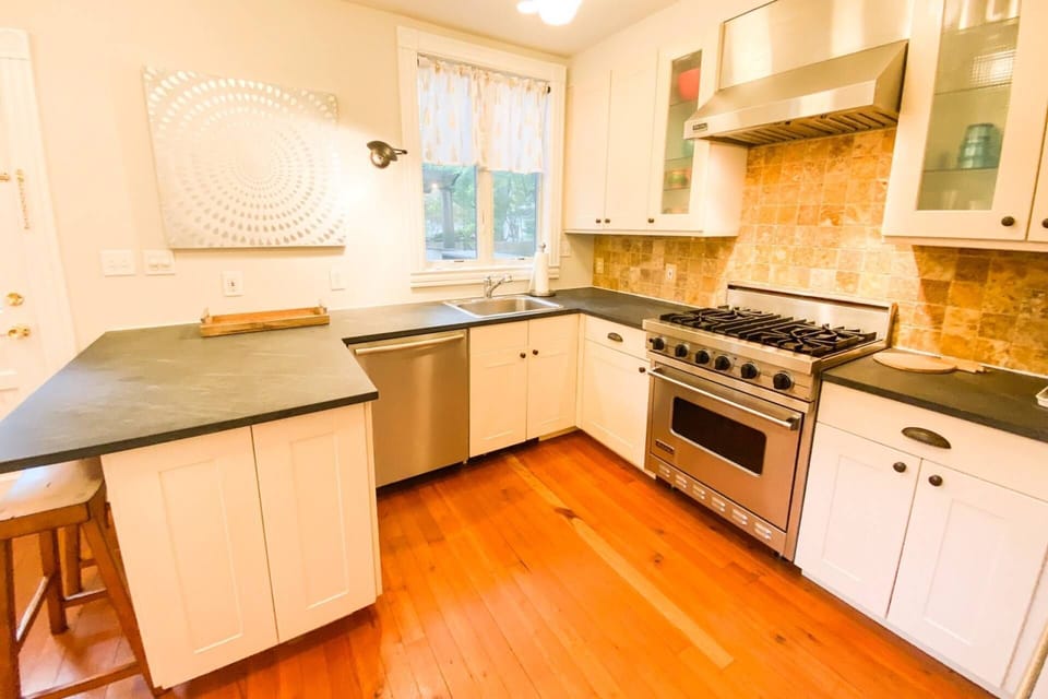 The sunny modern kitchen is fully-stocked with plates, silverware and cookware.
