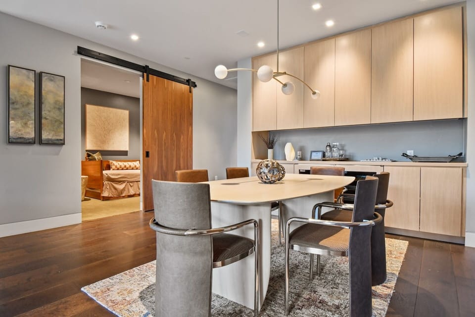 Gather around this sleek dining table where modern design meets warm wood tones, creating the perfect spot for your morning coffee or evening meals with loved ones.