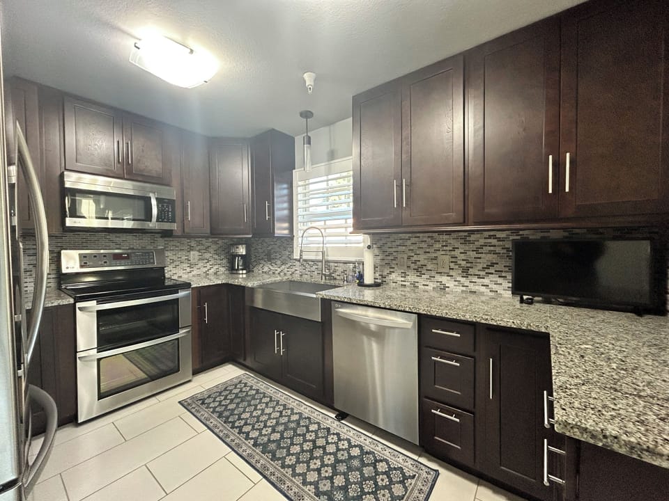 Well-appointed kitchen w/granite counters, stainless appliances, rich cabinetry