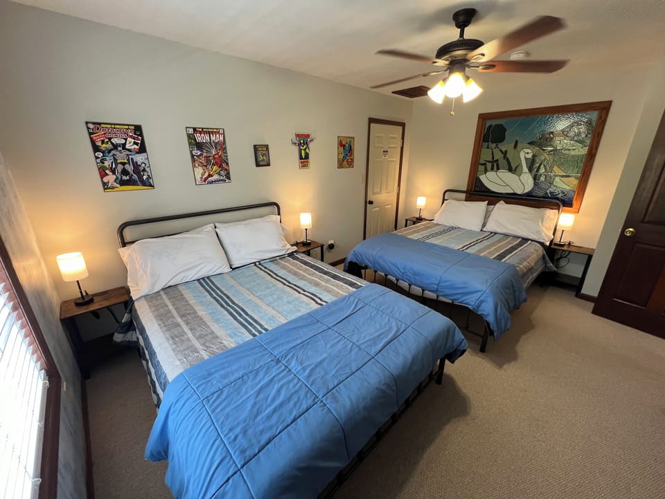 Upstairs guest bedroom #5 with two queen beds, superhero art & stained glass.