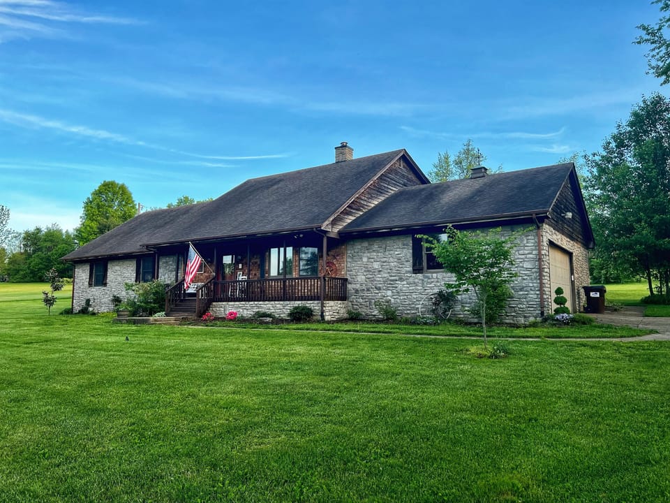 Front view of stone and cedar ranch with plenty of private parking