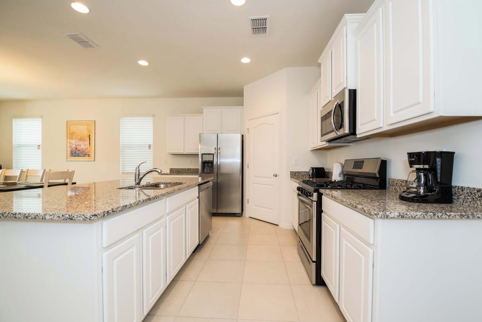 Modern kitchen with granite countertops and stainless steel appliances, perfect for cooking family meals.