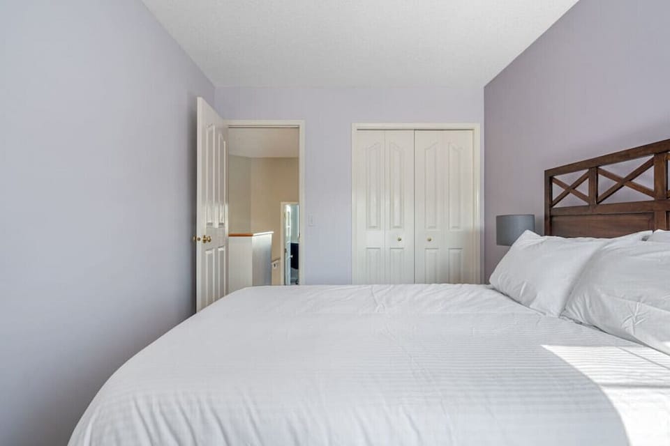 Third bedroom, located upstairs, with a queen bed, closet and blackout curtains.