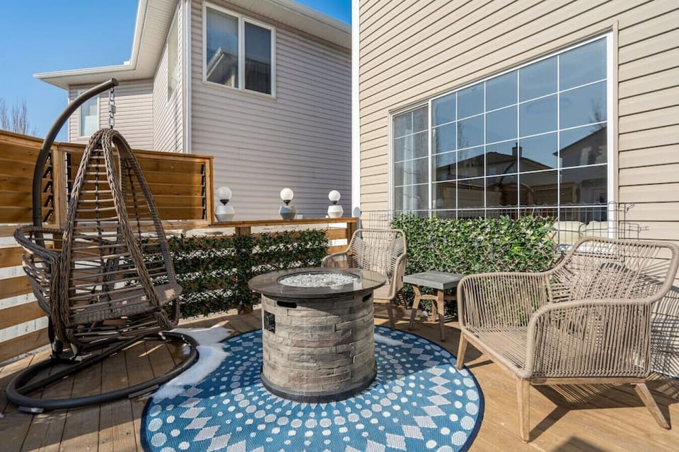 Private, fully fenced backyard with a BBQ, outdoor seating and a fire pit.