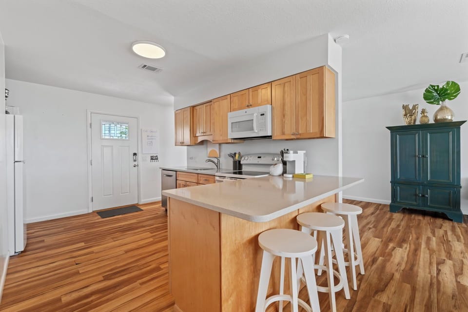 A bright, open kitchen with ample counter space and casual seating makes gathering easy and enjoyable. Whether you're serving up snacks or sharing stories, this inviting space is ready to host your crew with comfort and style.