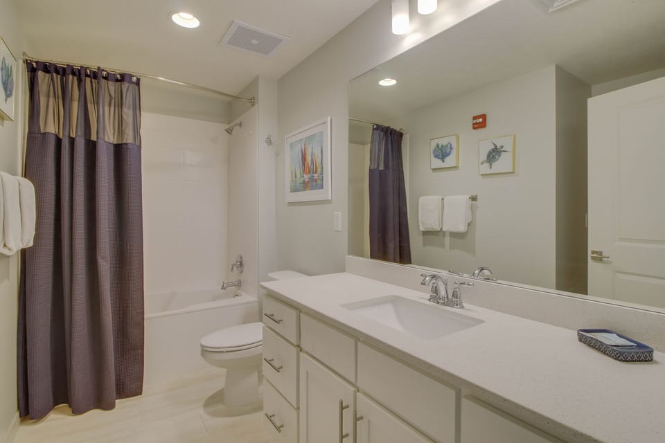 Guest bathroom with bathtub + shower combo + ample counterspace + large mirror!