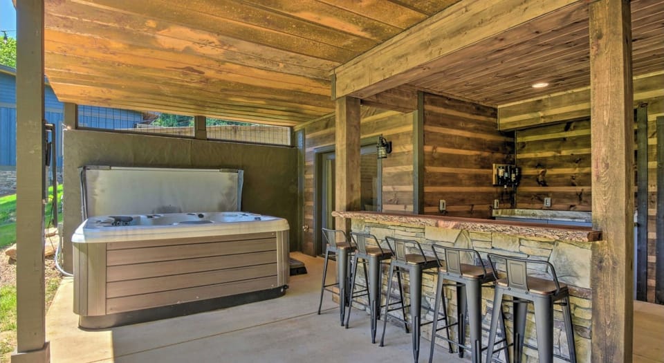 Downstairs hot tub and gathering area with bar, sink and refrigerator