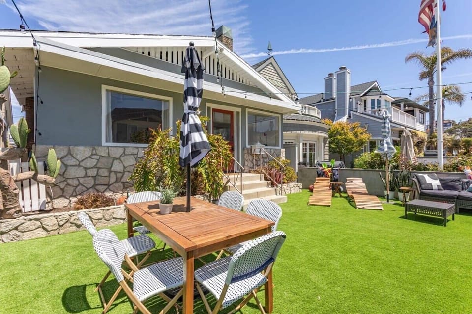 
Soak up the California sun in this sprawling, lush green backyard featuring a large outdoor dining table and comfortable lounge chairs for the ultimate alfresco experience.

