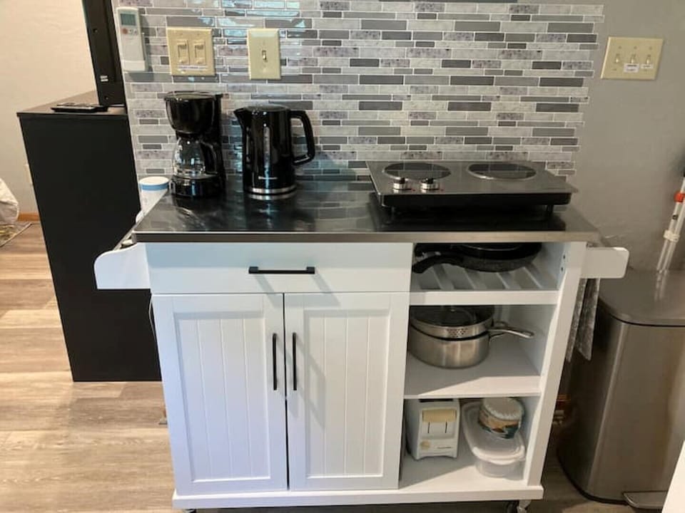 butcher block with double burner, microwave, tea kettle, coffee maker.