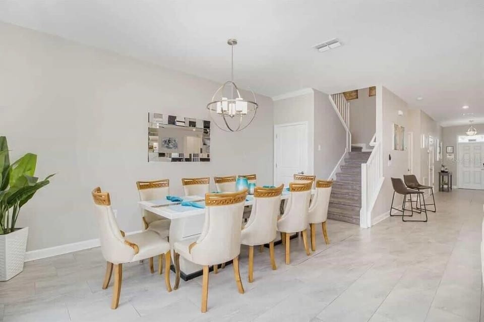 Elegant dining room with seating for ten, perfect for hosting gatherings under a chic chandelier in a spacious, inviting setting.