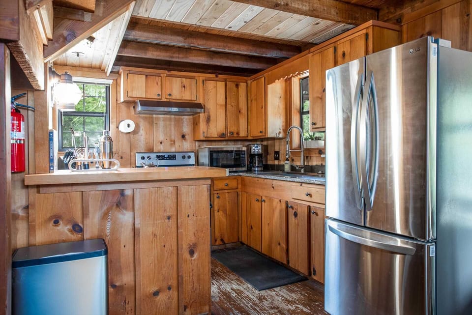 A full array of appliances, as well as cookware, dining ware, utensils, and glasses, await you in the rustic and functional country kitchen!