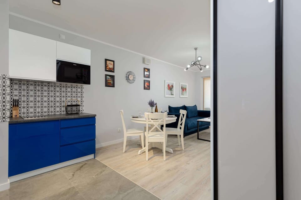 Another angle of the kitchen area, showing the blue cabinets, countertops, and a refrigerator. The kitchen opens up to a dining area.