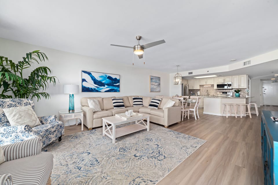 A comfortable living room with ample seating, flowing into a dining area, ideal for everyday living and gatherings.