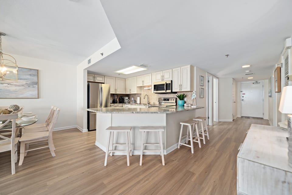 The heart of the home! This spacious kitchen with a breakfast bar provides a natural gathering spot, flowing effortlessly from the front entry to the dining and living areas.