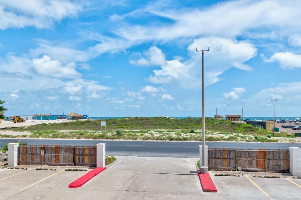 Property entrance with natural coastal landscape and convenient parking facilities nearby.