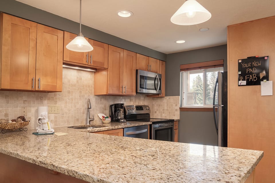 Your fully equipped kitchen awaits with granite counters, stainless appliances, and warm wood cabinetry—perfect for cooking memorable meals together.