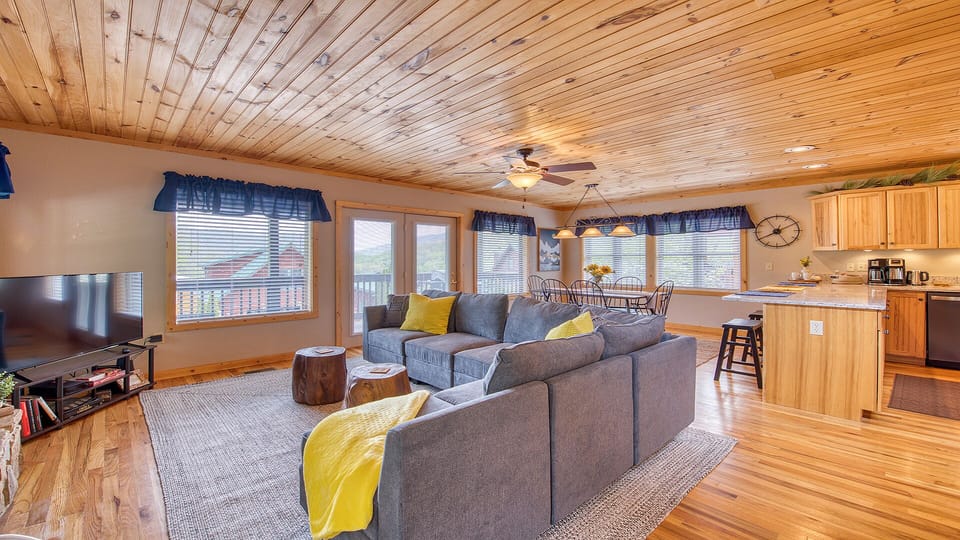 The light pours in from the multiple windows in this log cabin home.