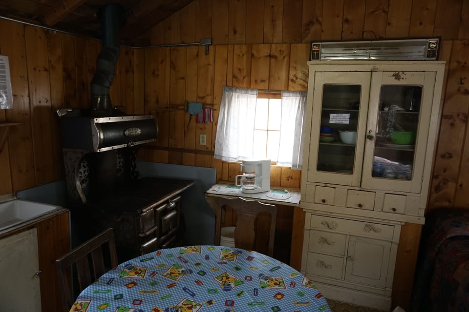 Cabin 6 is a cozy rustic cabin that features a wood-burning stove. (2)