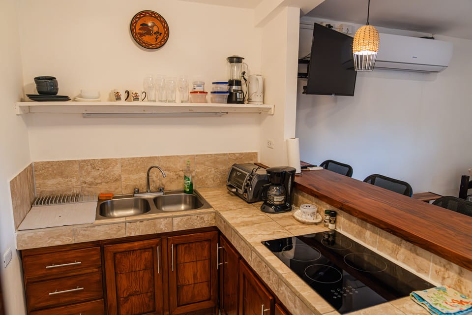 Full service kitchen with stove and bar seating for three. 