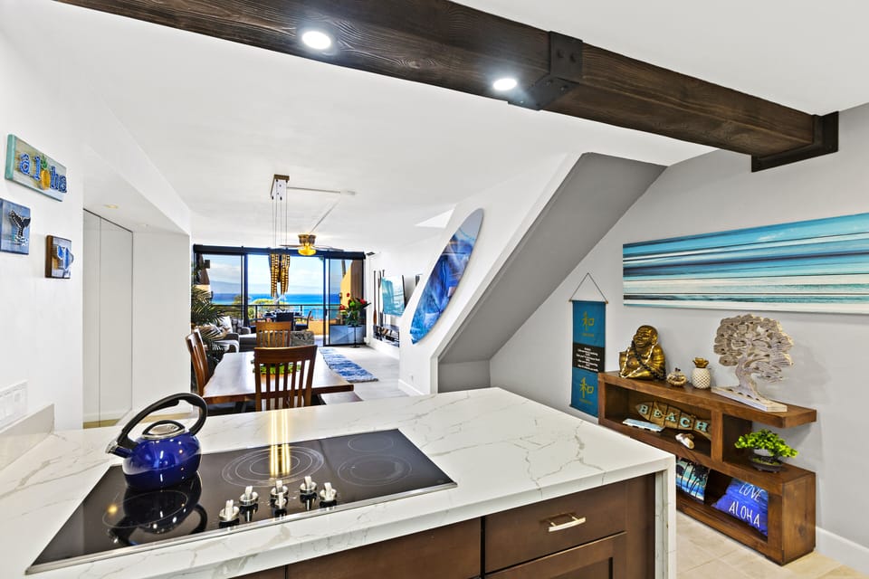 Enjoy a fully stocked kitchen with stylish decor, modern lighting, and an ocean view from the breakfast bar—perfect for preparing meals in paradise.