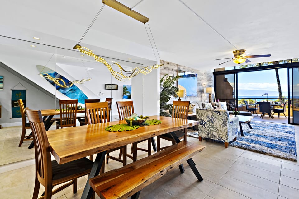This spacious dining area, with a natural wood table and modern island decor, invites guests to enjoy home-cooked meals with an incredible ocean view.