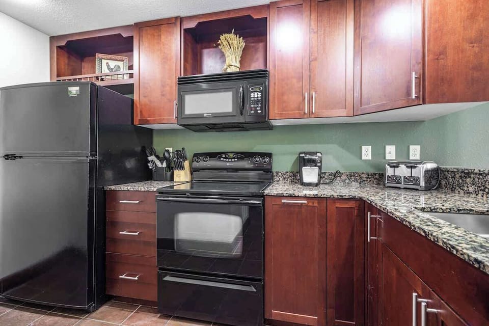 The kitchen is fully stocked with modern appliances - fridge, freezer, stovetop, oven, microwave, toaster, and Keurig coffeemaker!