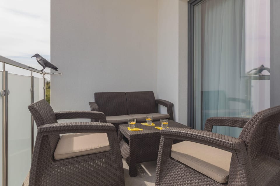 Balcony space with a table and chairs, ideal for enjoying a cup of coffee in the fresh air.