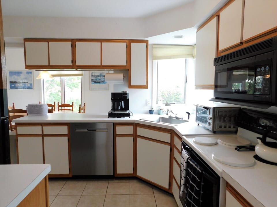 541D Hudson Avenue - Kitchen Interior - A modern, efficient kitchen featuring crisp white cabinetry, high-end stainless steel appliances, and plenty of counter space for vacation meal prep.