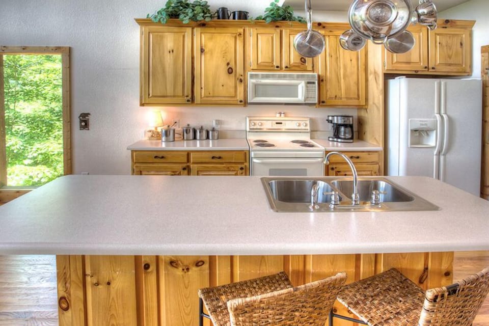 Kitchen sink and prep with bar and two stools