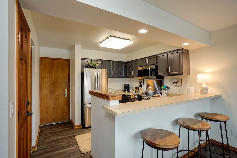 Your fully equipped kitchen features modern appliances, granite counters, and a breakfast bar where you can enjoy morning coffee.