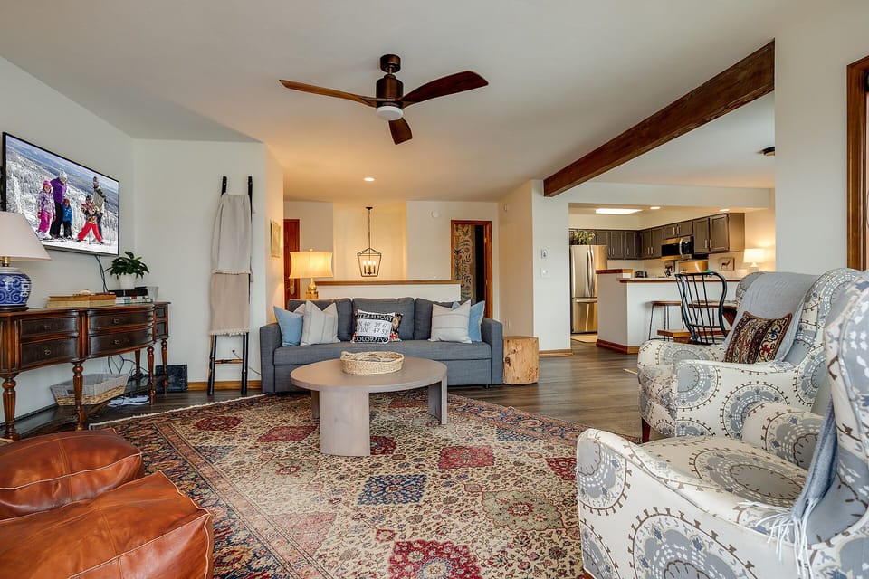 Relax in your spacious living area with elegant furnishings, exposed beams, and an open kitchen perfect for gatherings.