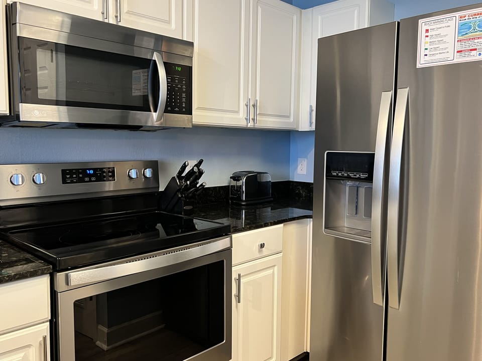 View of stove, microwave and refrigerator with filtered water and ice maker