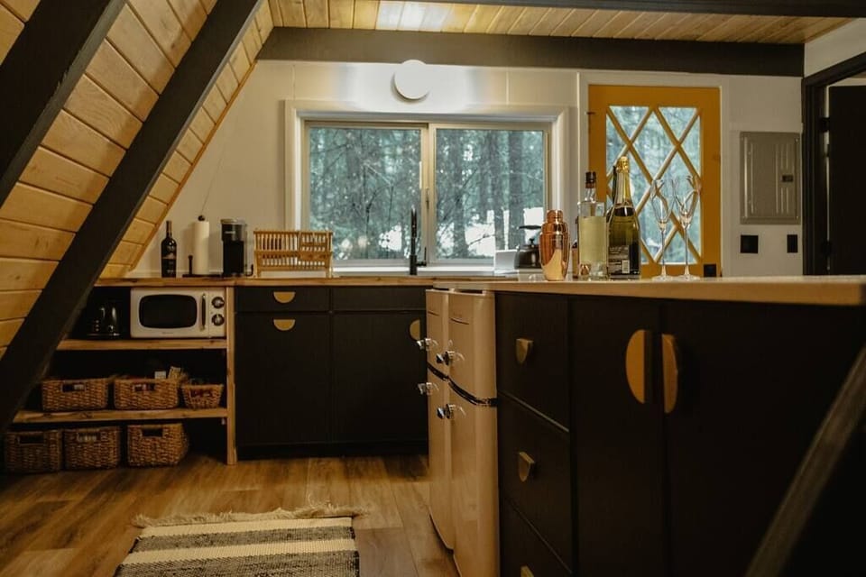 Remodeled kitchen including 2 mini refrigerators, small oven and electric cooktop, toaster and microwave.