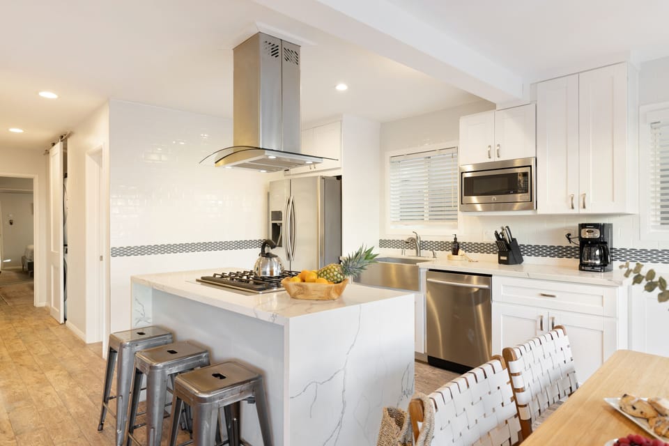 Spacious kitchen with a gas stove and island seating.