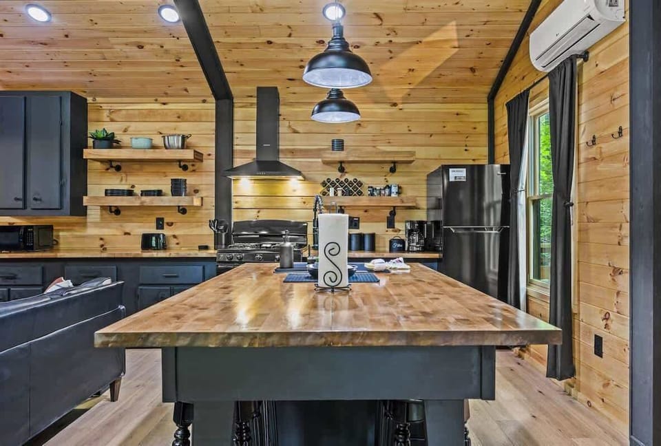 Modern kitchen with black island and wood countertop for rustic charm