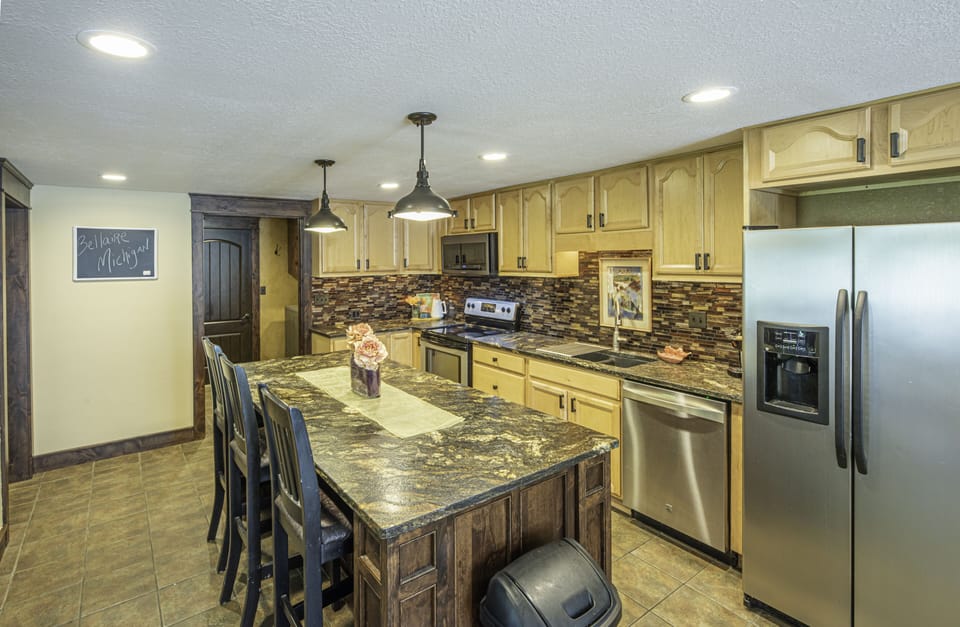 Kitchen has large quartzite island with extra bar stools to hang around.