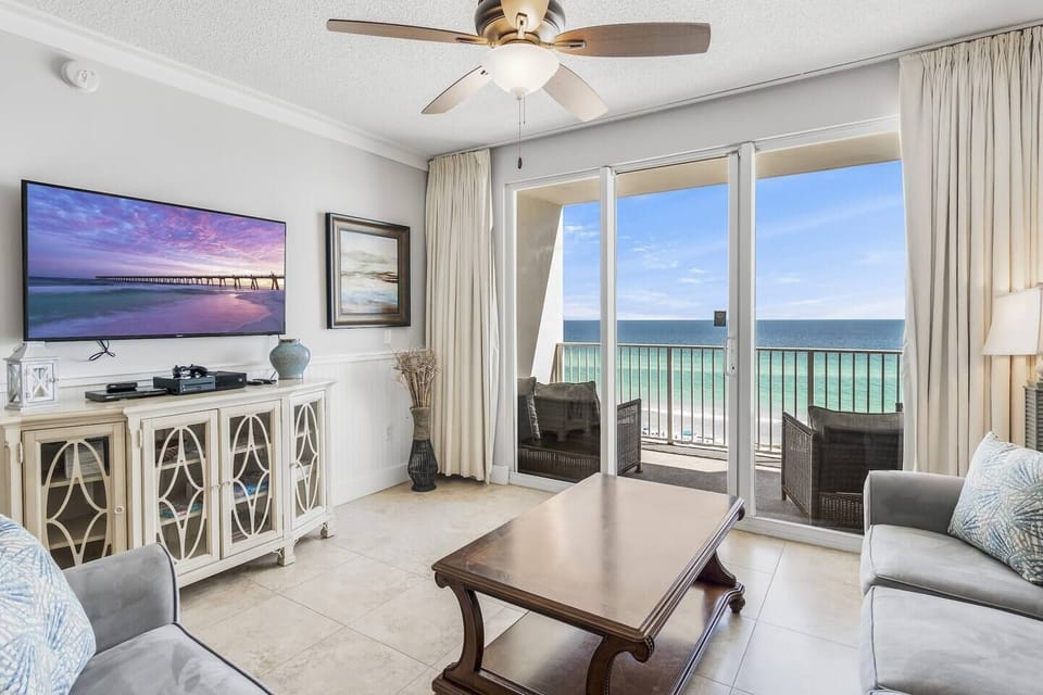 Open living and dining space with tall ceilings, Gulf views, and plenty of seating (Queen Sleeper Sofa + Love Seat w/ Full Sleeper) around a large Smart TV for Netflix, Prime TV, etc.